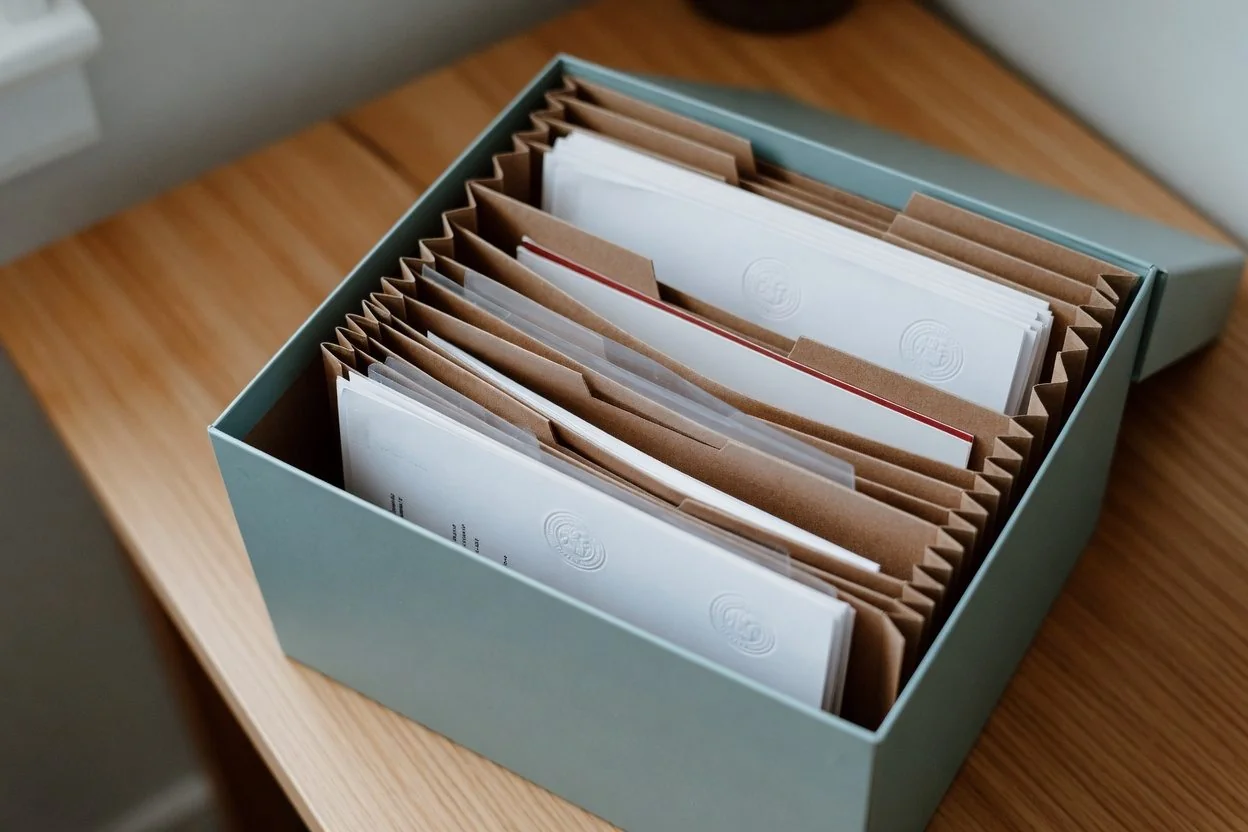 A folder labelled "IMM 5409" beside a folder labelled "supporting evidence" on a desk, with a notary seal in the foreground
