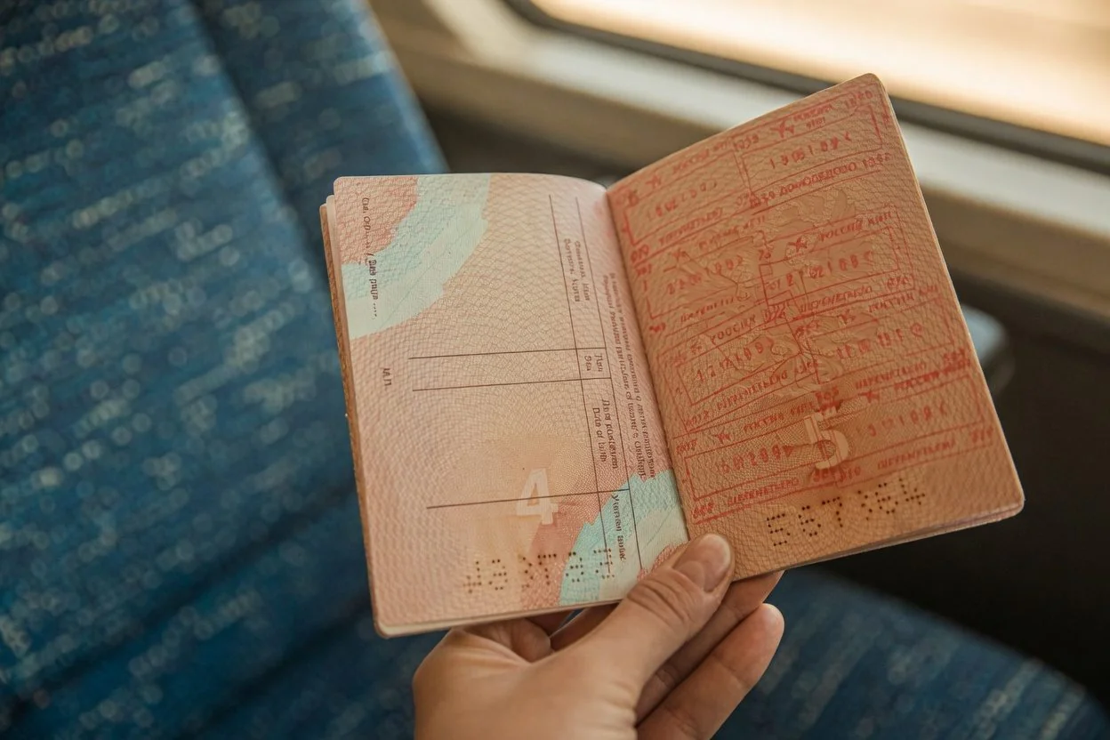 Two pieces of Canadian government ID — a passport and an Ontario driver's licence — laid beside a printed letter of invitation, ready for an Ottawa notary appointment
