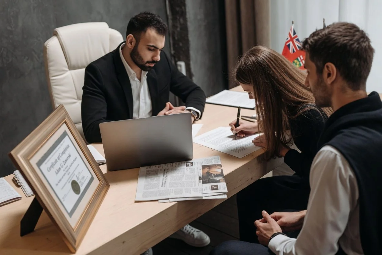 Couple meeting with a notary at a wooden desk with passports, a divorce decree, and a draft declaration spread out